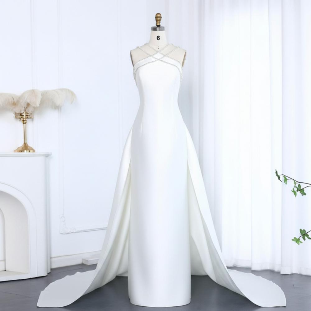 White satin mermaid evening gown with a beaded halter neckline, detachable overskirt, and floor-length train.