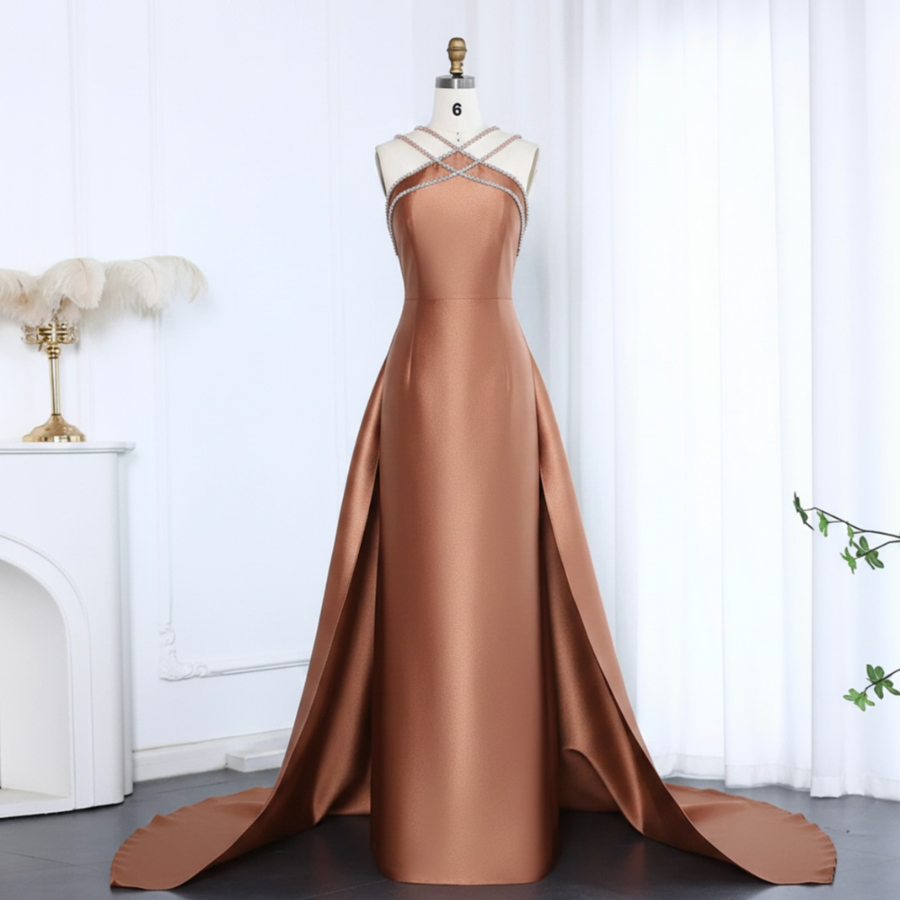 Bronze satin mermaid evening gown with a crystal-beaded halter neckline and dramatic detachable overskirt train.