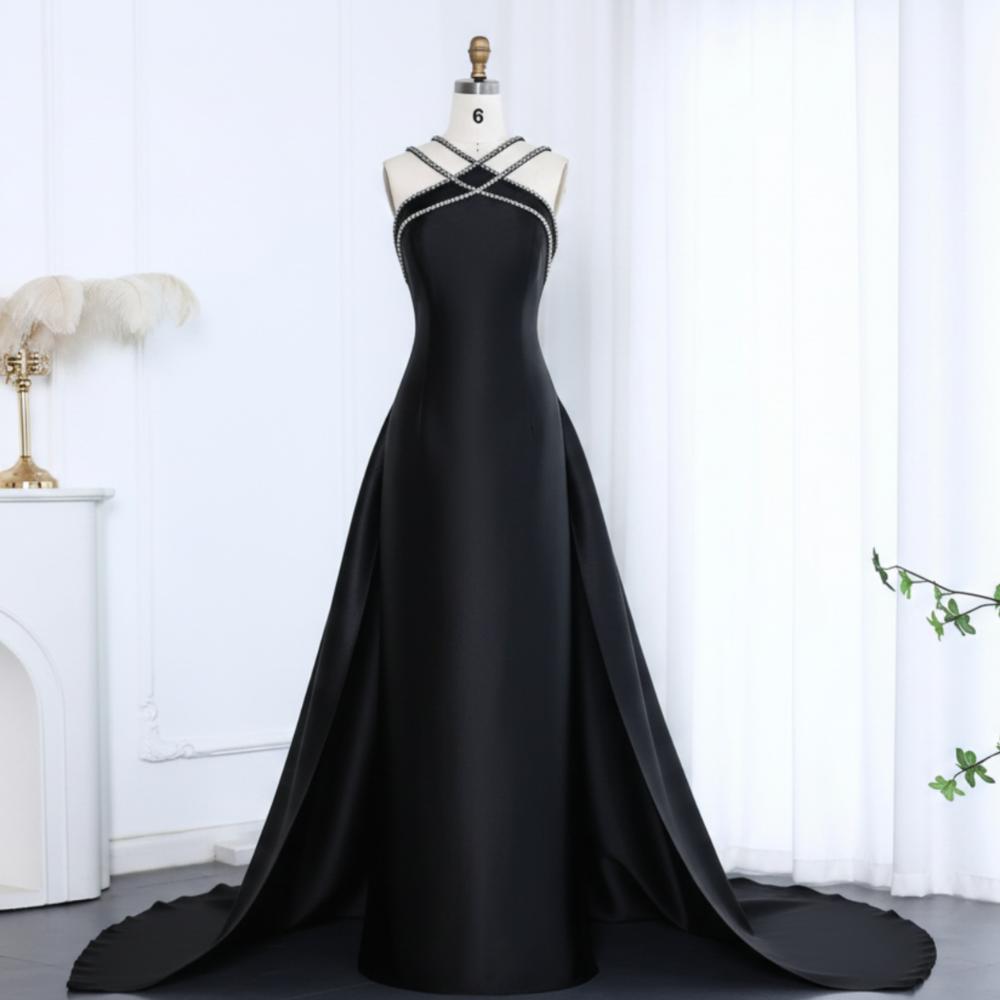 Black satin mermaid evening gown with a crystal-beaded halter neckline and dramatic detachable overskirt train.