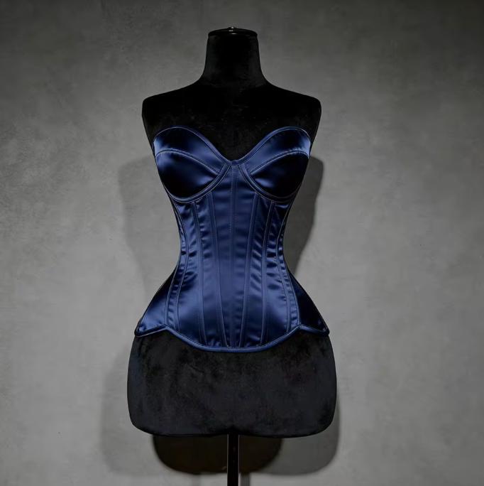 Navy blue satin overbust corset with structured cups and steel boning on a black mannequin display.