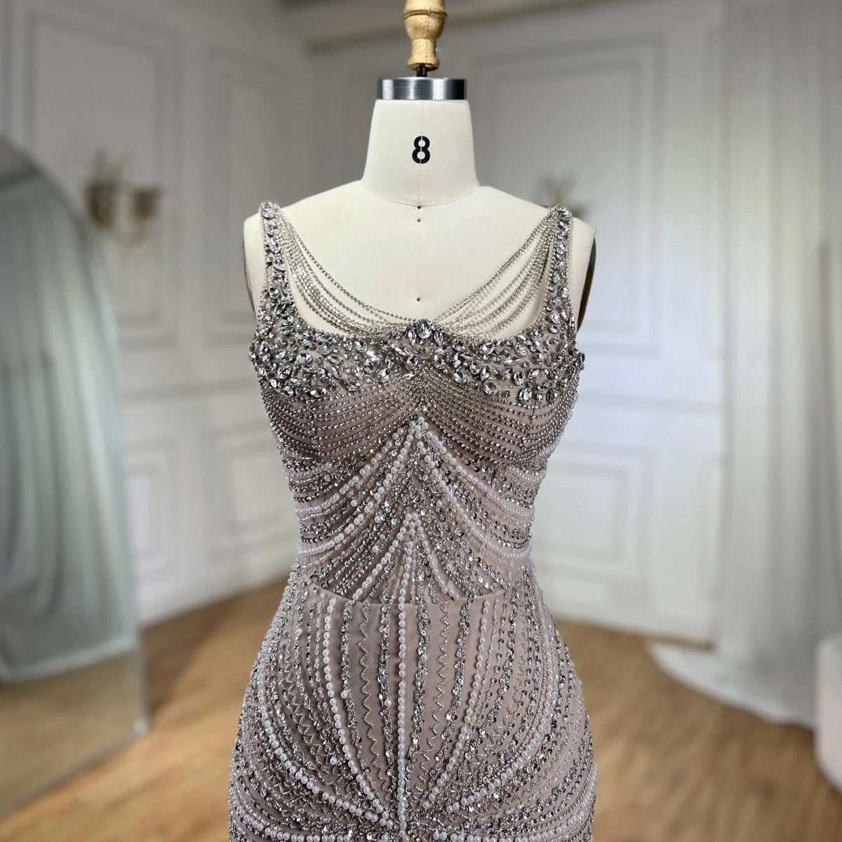 Nude mermaid gown with square neckline, featuring intricate hand-beaded crystals, pearls, and sequins on tulle fabric.