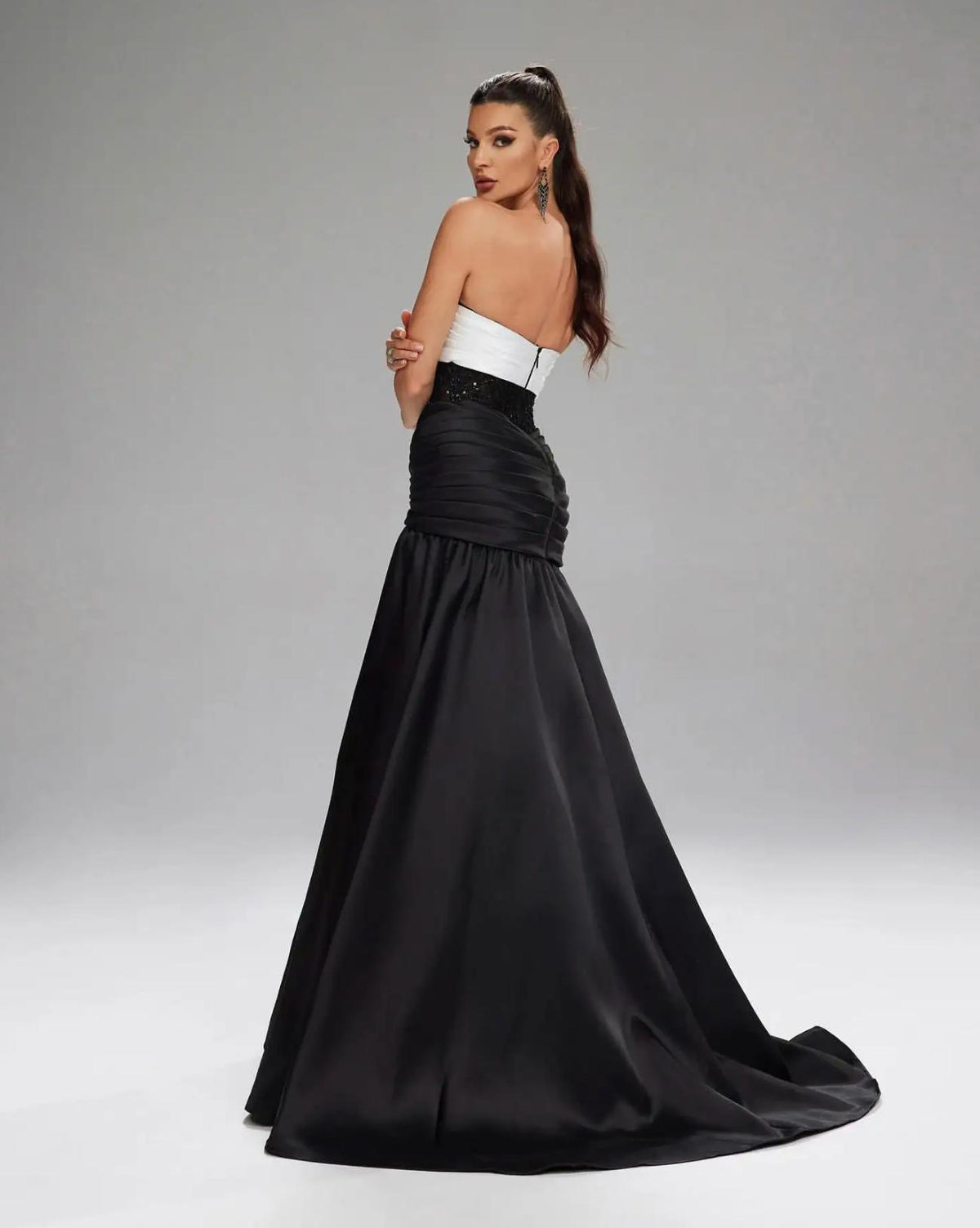 Basra mermaid evening gown featuring a white sweetheart bodice, black sequin waist, and pleated satin floor-length skirt.