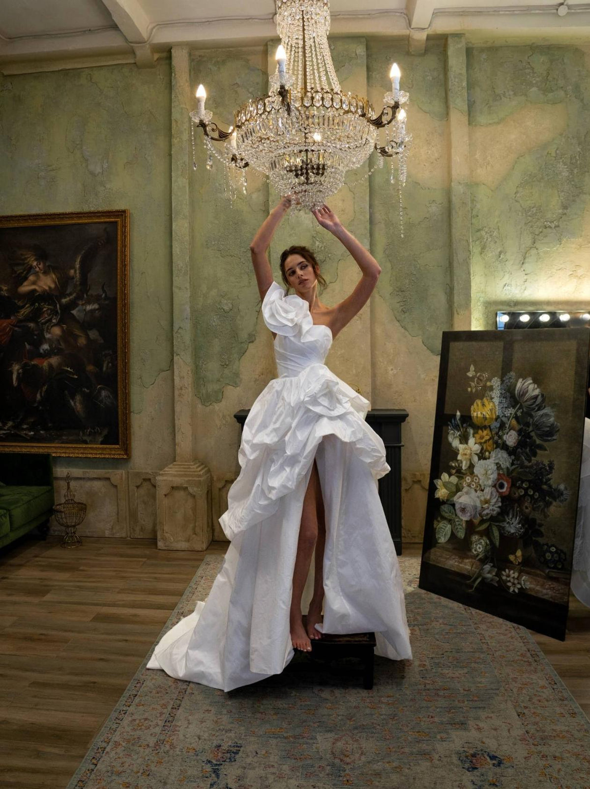 One-shoulder white taffeta ball gown with floral bodice embellishments and a high side slit in a vintage room.