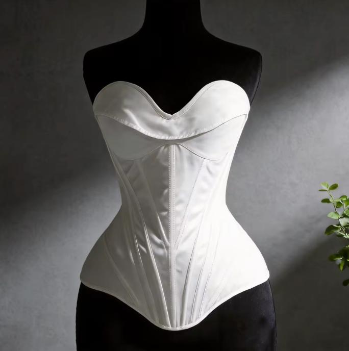 White satin Bella corset bustier with structured boning and sweetheart neckline on a black mannequin.