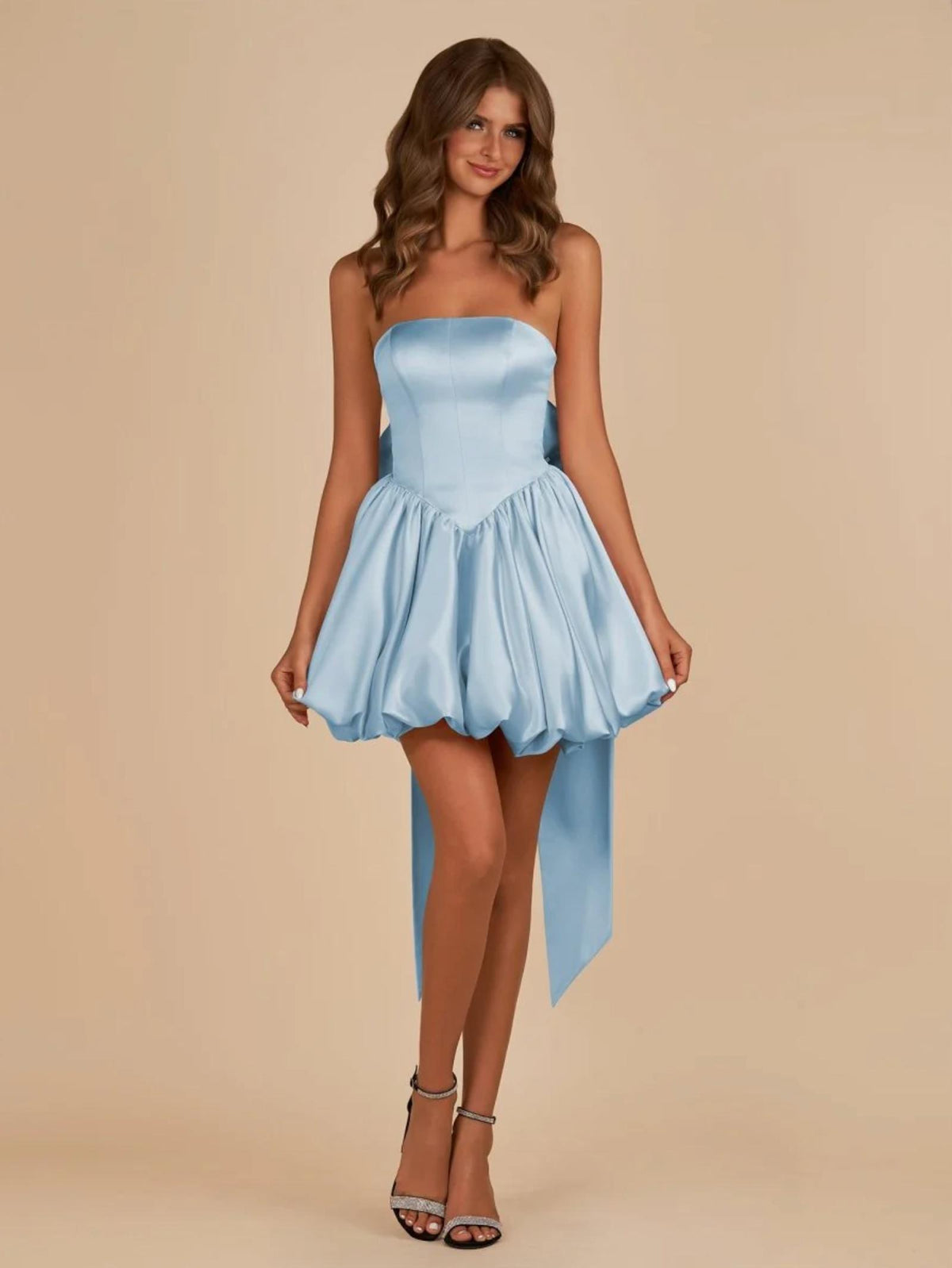 Light blue satin mini dress with a strapless corset bodice, voluminous bubble skirt, and a large detachable back bow.