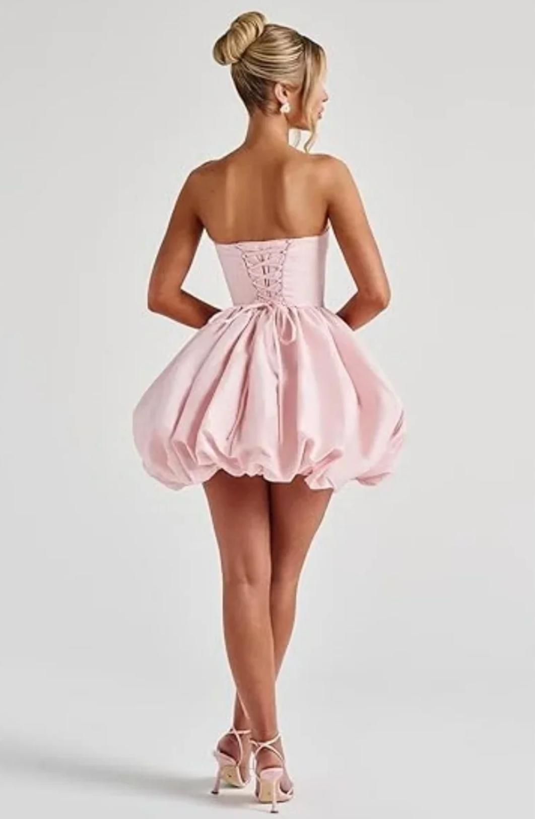 Pink satin mini dress with a corset lace-up back and voluminous bubble skirt silhouette.