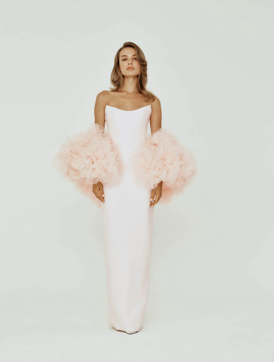 Strapless Mikado satin column gown with a dramatic, hand-crafted organza flower cape in soft blush pink.