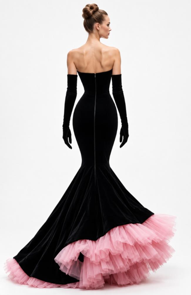 Black velvet strapless mermaid gown with opera gloves and a voluminous ruffled pink tulle hem.