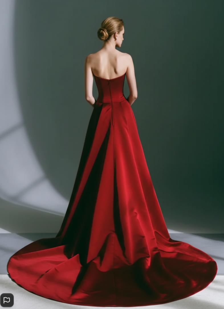 Back view of a sleeveless red taffeta gown with a structured bodice and a long, elegant removable train.