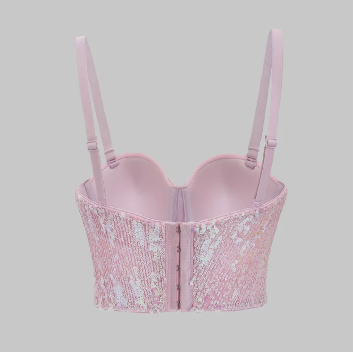 Back view of a pink Y2K-style corset bustier featuring shimmering sequins, adjustable straps, and a hook-and-eye back closure.
