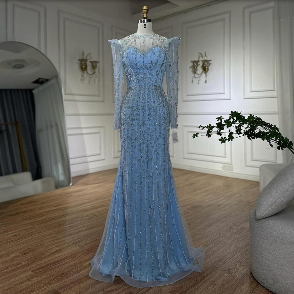 Light blue mermaid gown with long sleeves, intricate silver beading, pearl embellishments, and a sheer tulle overlay.