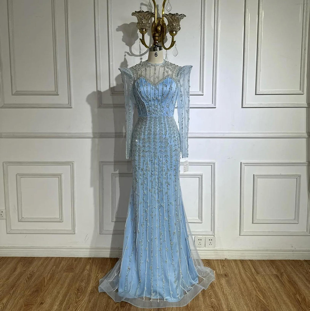 Light blue mermaid gown with intricate silver beading, crystals, pearls, long sleeves, and a sheer o-neck bodice.