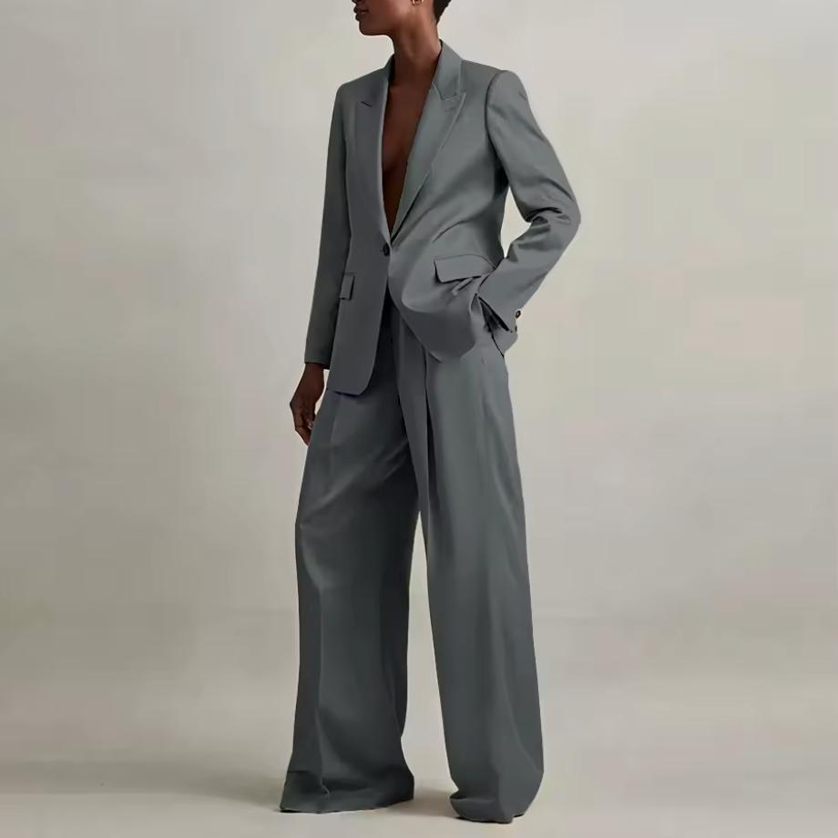 Model wearing a grey silk satin pant suit with an oversized single-button blazer and wide-leg trousers.