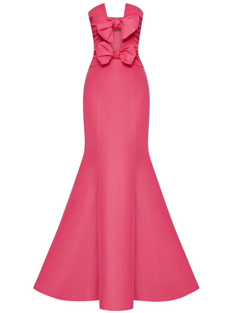 Hot pink silk faille mermaid ballgown with a plunging split neckline, bow adornments, and a fluted floor-length skirt.