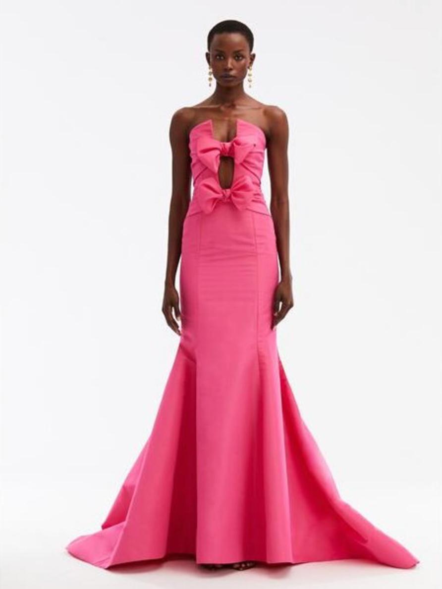 Hot pink silk faille mermaid ballgown with a plunging split neckline, bow adornments, and a floor-sweeping fluted skirt.