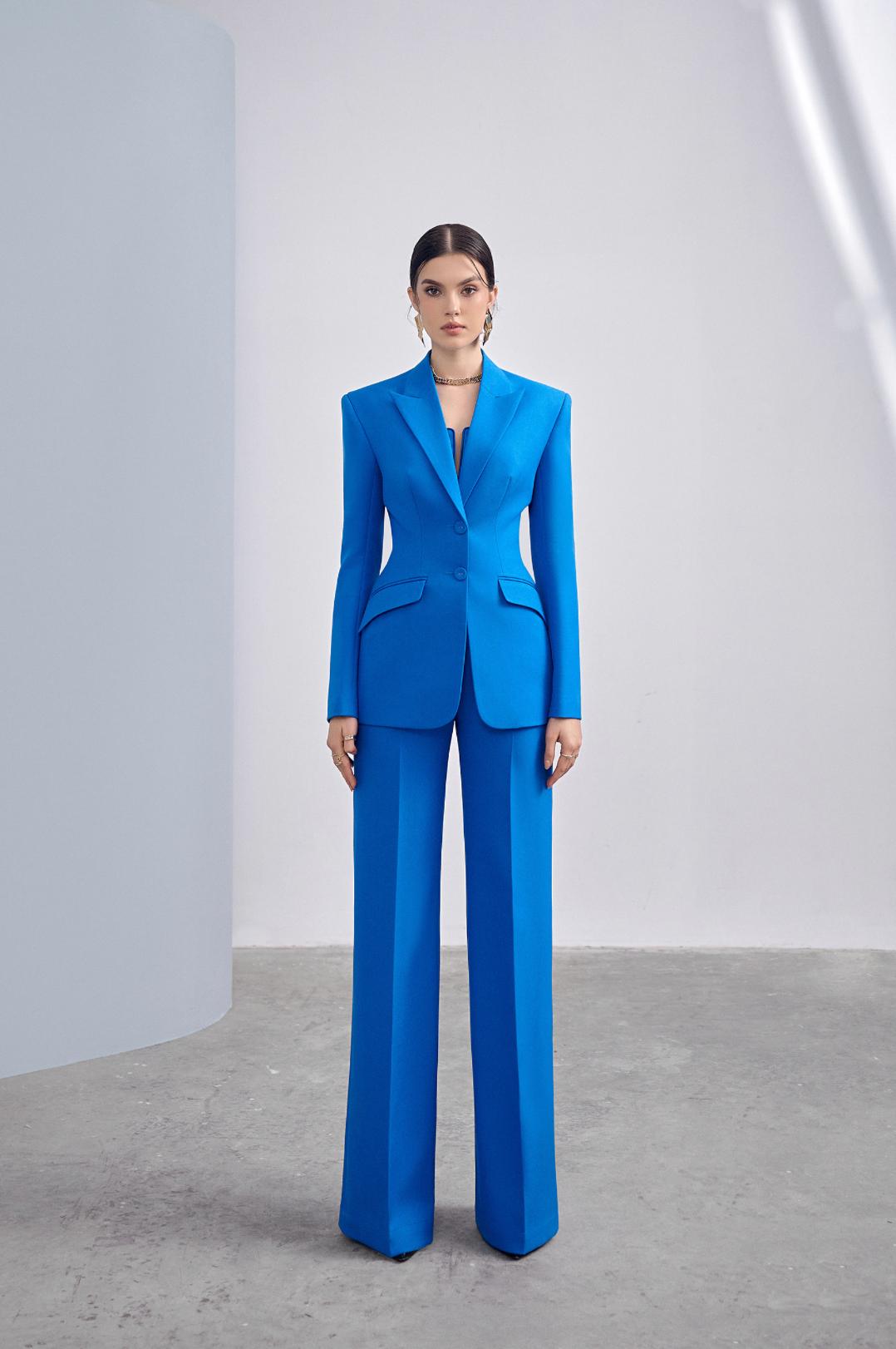 Woman wearing a vibrant blue two-piece business suit with a tailored single-breasted blazer and wide-leg trousers.