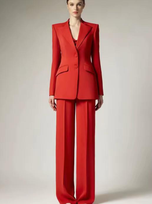 Model wearing a vibrant red two-piece business suit with a sharp-shouldered single-breasted blazer and wide-leg trousers.