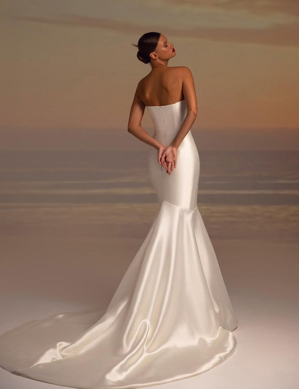 Elegant white satin fishtail gown with a strapless bodice and long train, perfect for formal black-tie events.