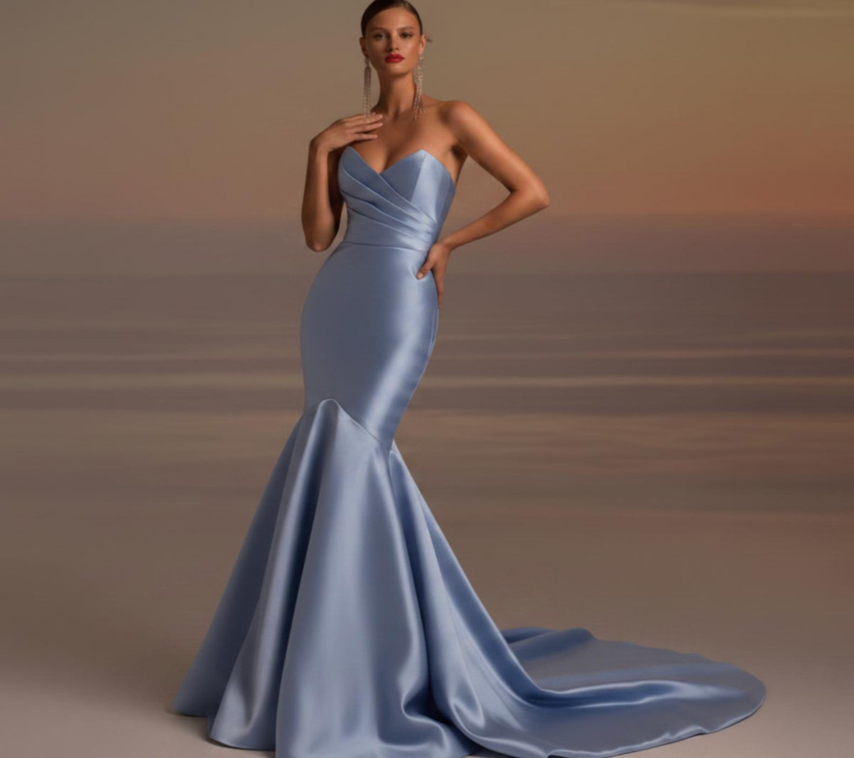 Model wearing a light blue satin fishtail gown with a strapless pleated bodice and elegant floor-length train.