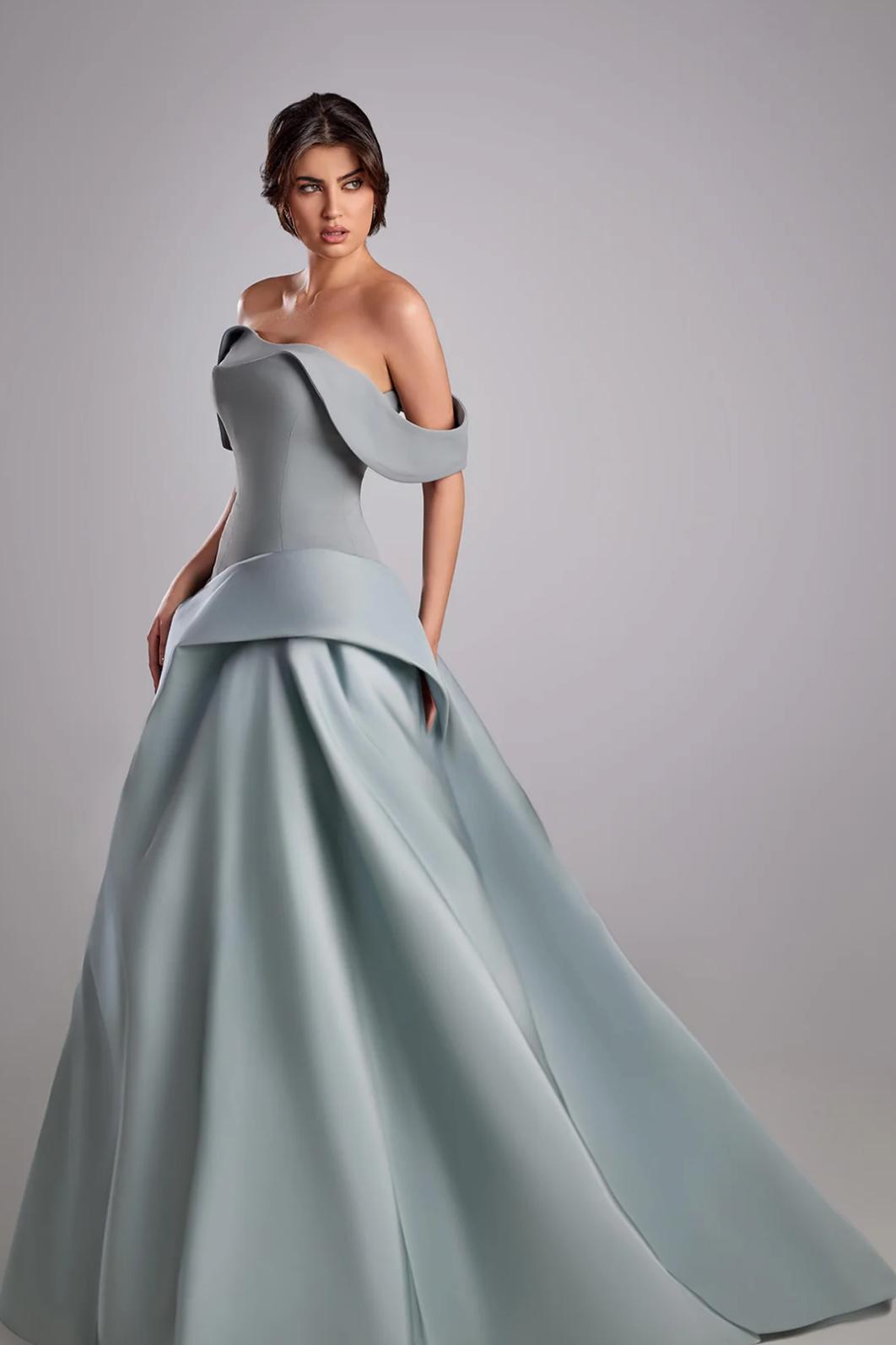 Bravaria off-shoulder gown in light blue satin with a fitted pleated bodice and structured mikado satin skirt.
