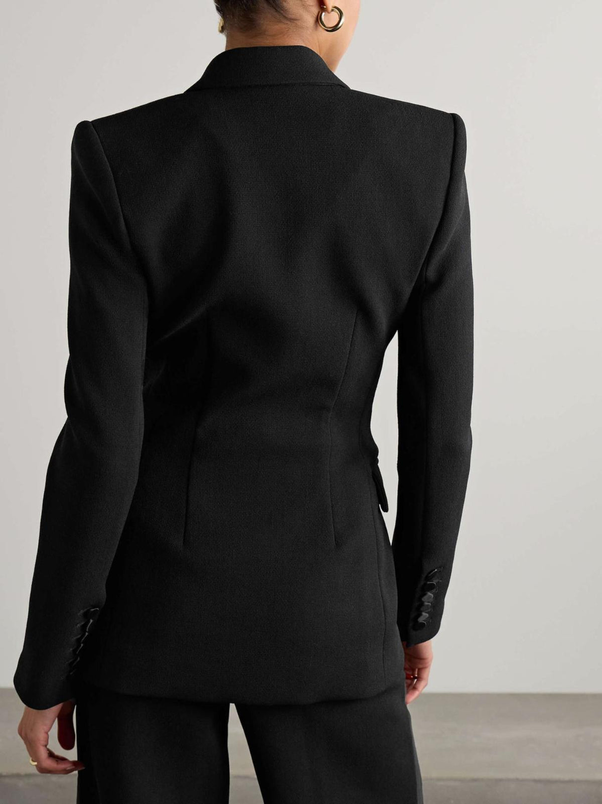 Back view of a tailored black Brioni Vanqui suit jacket with structured shoulders and sleek, professional lines.