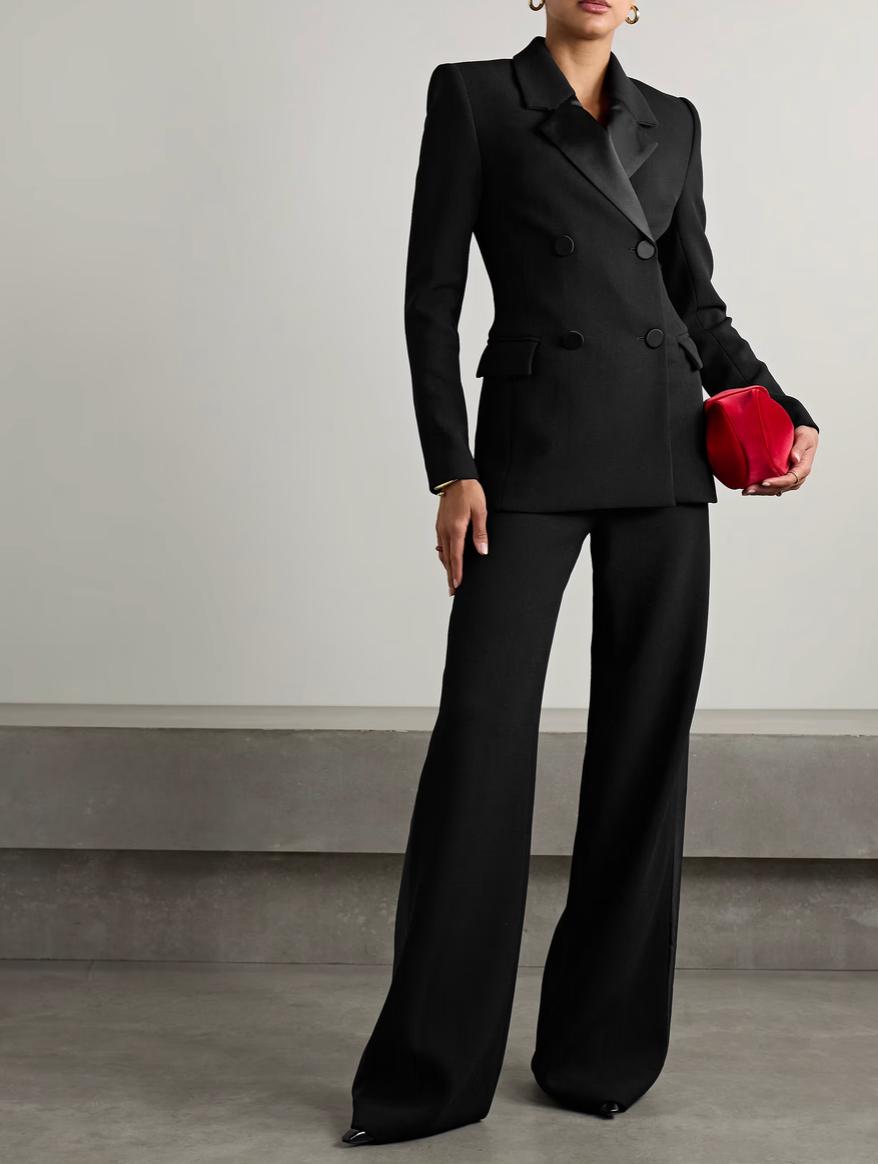 Black double-breasted Brioni suit with satin peaked lapels, tailored jacket, and wide-leg trousers on a model.