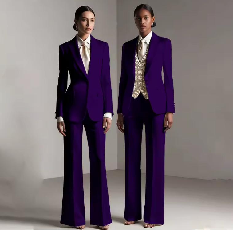 Two models wearing tailored deep purple satin single-breasted pantsuits with white shirts and formal trousers.