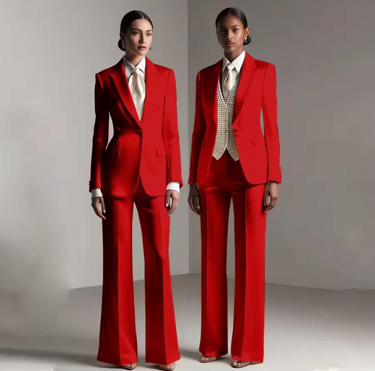 Two models wearing tailored red satin single-breasted pantsuits with white shirts and formal trousers.