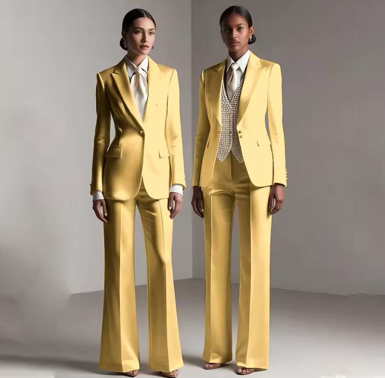 Two models wearing yellow satin Brisbane two-piece pantsuits with tailored single-breasted jackets and coordinating trousers.