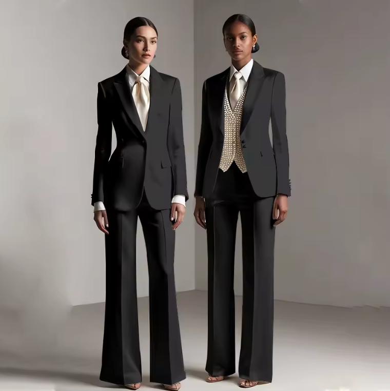 Two models wearing tailored black satin Brisbane pantsuits with single-breasted jackets and wide-leg trousers.
