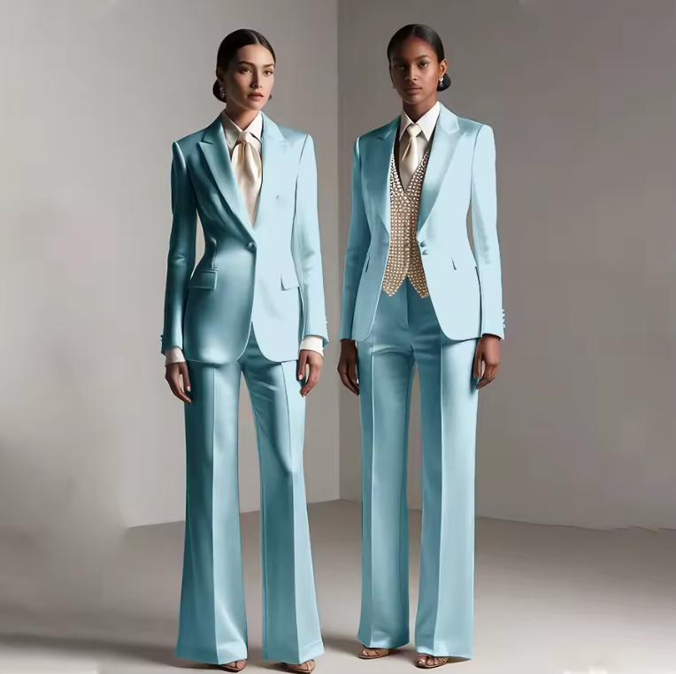 Two models wearing tailored light blue satin single-breasted pantsuits with matching trousers and elegant shirts.