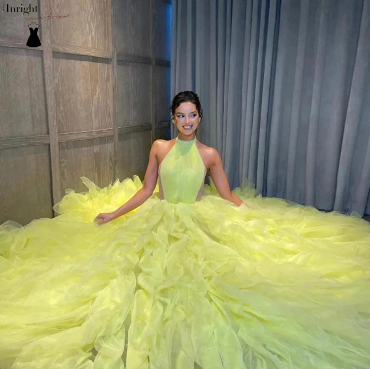 Yellow halter ball gown with tiered tulle pleating, a natural waistline, and a dramatic floor-sweeping train.