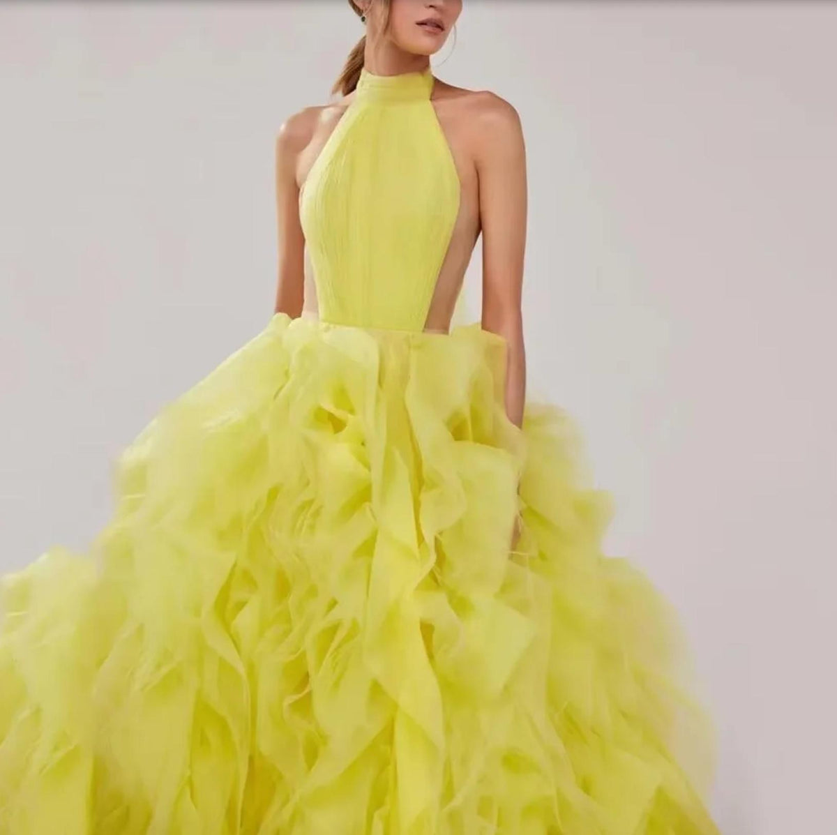 Bright yellow halter ball gown featuring a pleated bodice and dramatic, voluminous tiered tulle skirt.