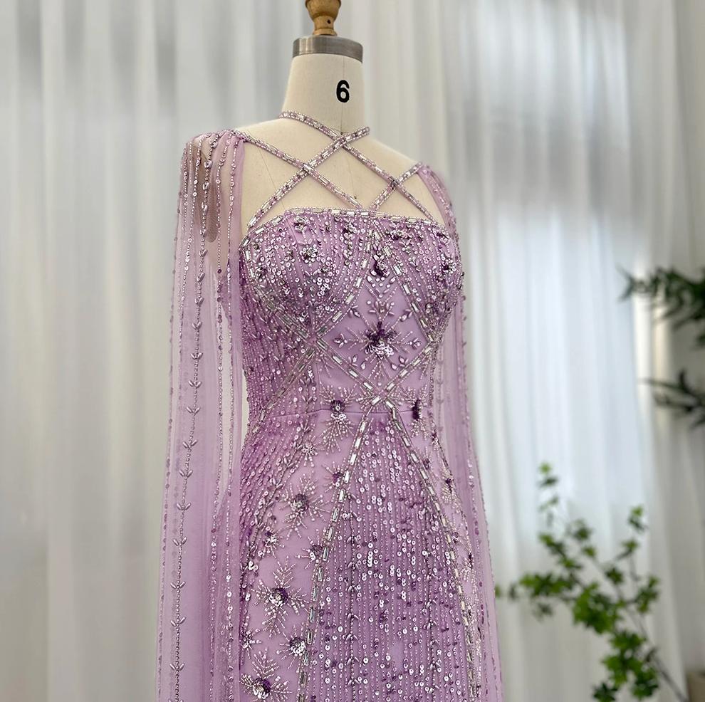 Lavender mermaid gown with cape sleeves, criss-cross neckline, and intricate crystal, sequin, and bead embellishments.