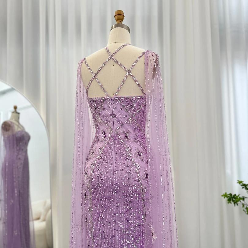 Lavender mermaid gown with tulle cape sleeves, intricate crystal beading, and a criss-cross back on a mannequin.