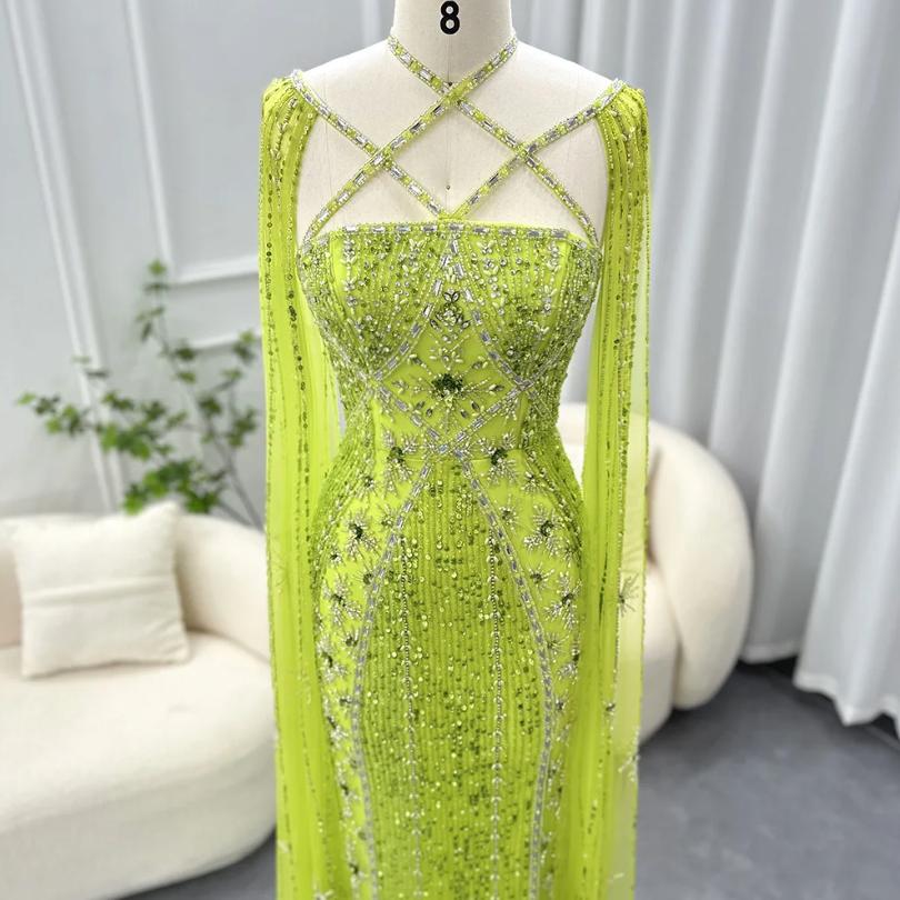 Lime green mermaid gown with cape sleeves, criss-cross neckline, and intricate crystal and sequin embellishments.