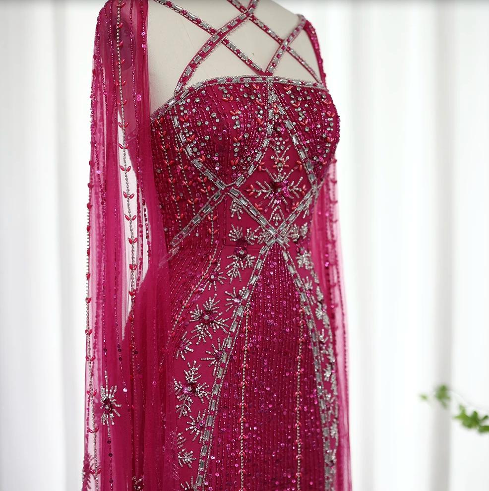 Fuchsia mermaid gown with tulle cape sleeves, intricate silver beading, shimmering crystals, and a criss-cross neckline.
