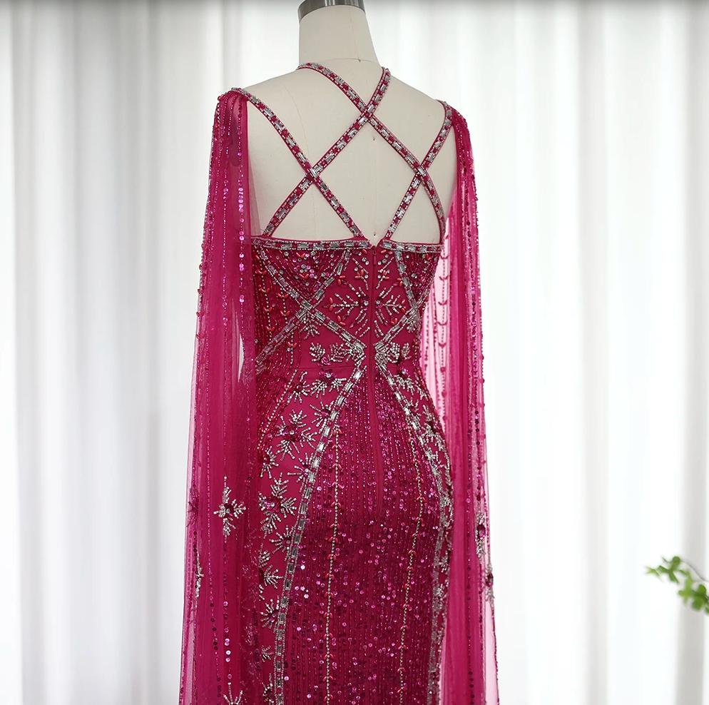 Fuchsia mermaid gown with cape sleeves, criss-cross back, and intricate crystal, sequin, and bead embellishments.
