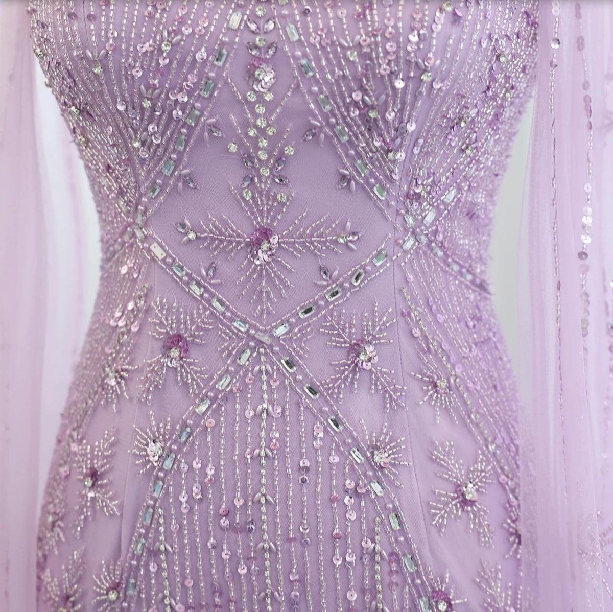 Lavender tulle mermaid gown featuring intricate silver beading, shimmering crystals, and sequin starburst patterns.