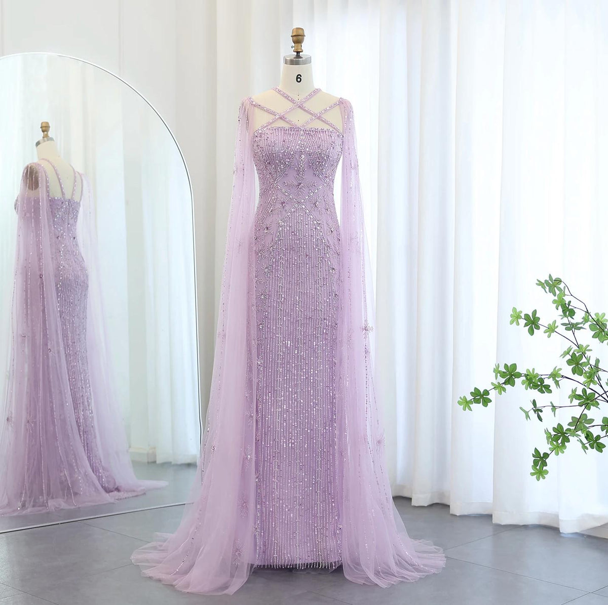 Lavender mermaid gown with cape sleeves, criss-cross neckline, and intricate crystal and sequin beading on tulle.