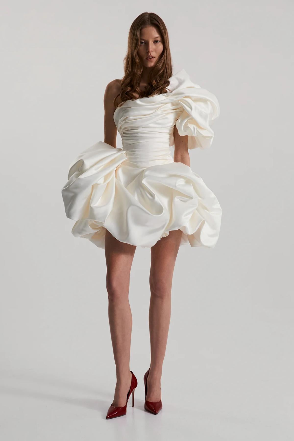 White strapless mini dress in ruched satin with a ruffled sweetheart neckline and voluminous A-line skirt.