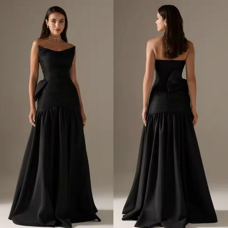 Black strapless satin A-line evening gown with a pleated bodice and a dramatic bow on the backless design.