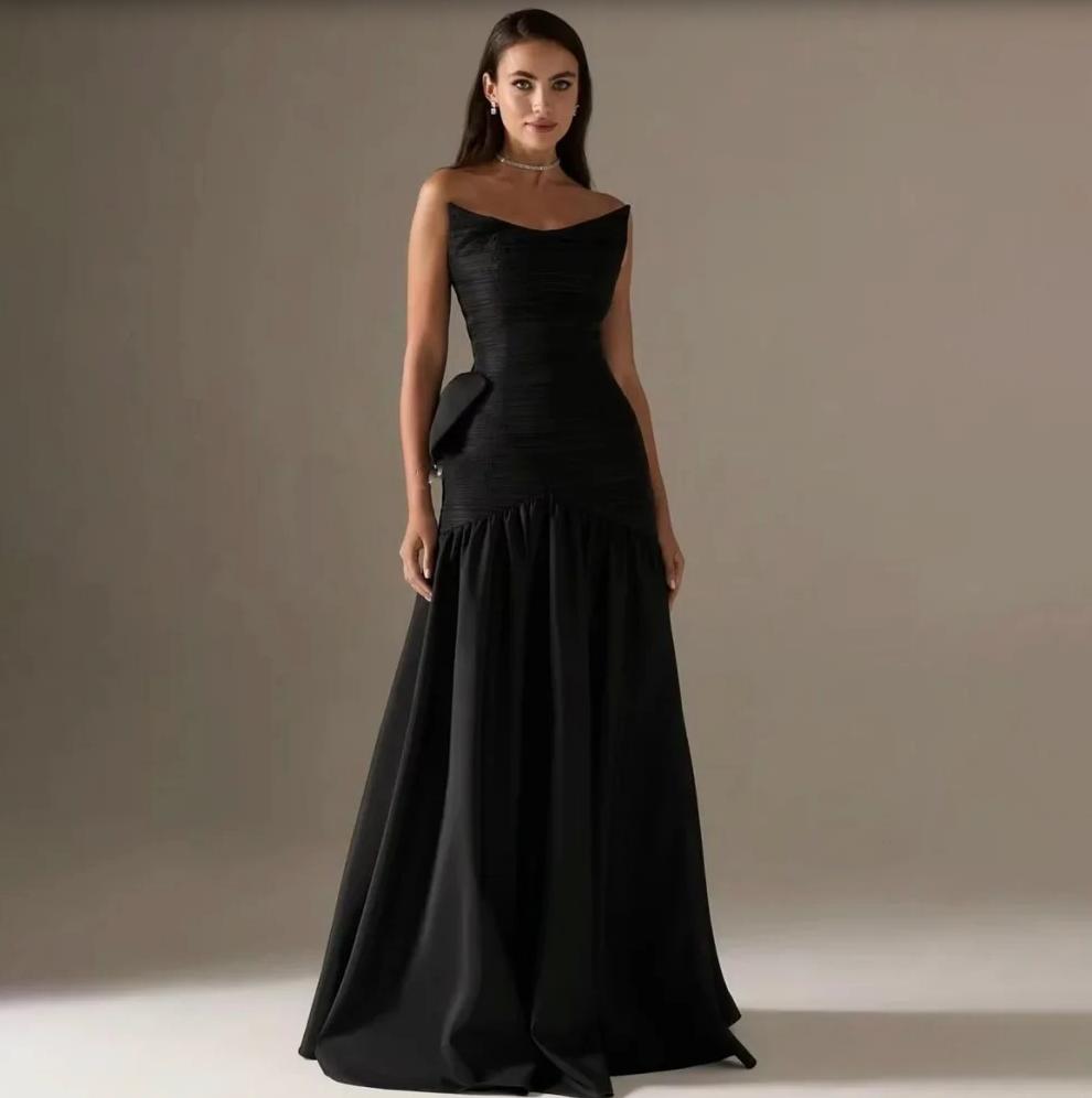 Black strapless A-line Candelaria gown in pleated satin with a dramatic back bow and floor-length silhouette.