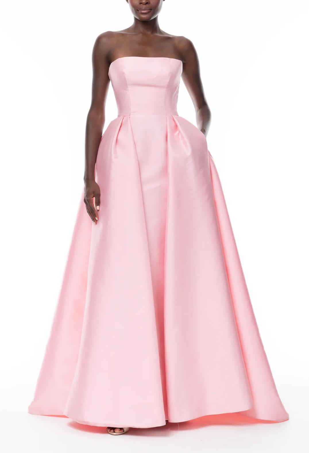 Strapless pink satin Carnation gown with a structured bodice and a full, pleated floor-length skirt.