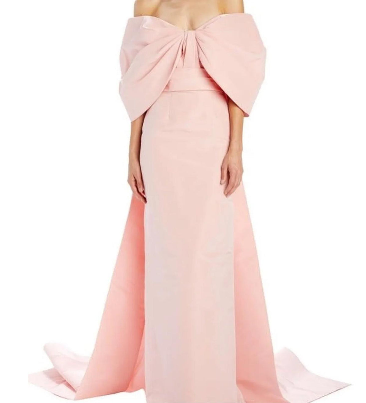 Blush pink off-the-shoulder gown featuring a dramatic oversized bow, fitted bodice, and a flowing floor-length train.
