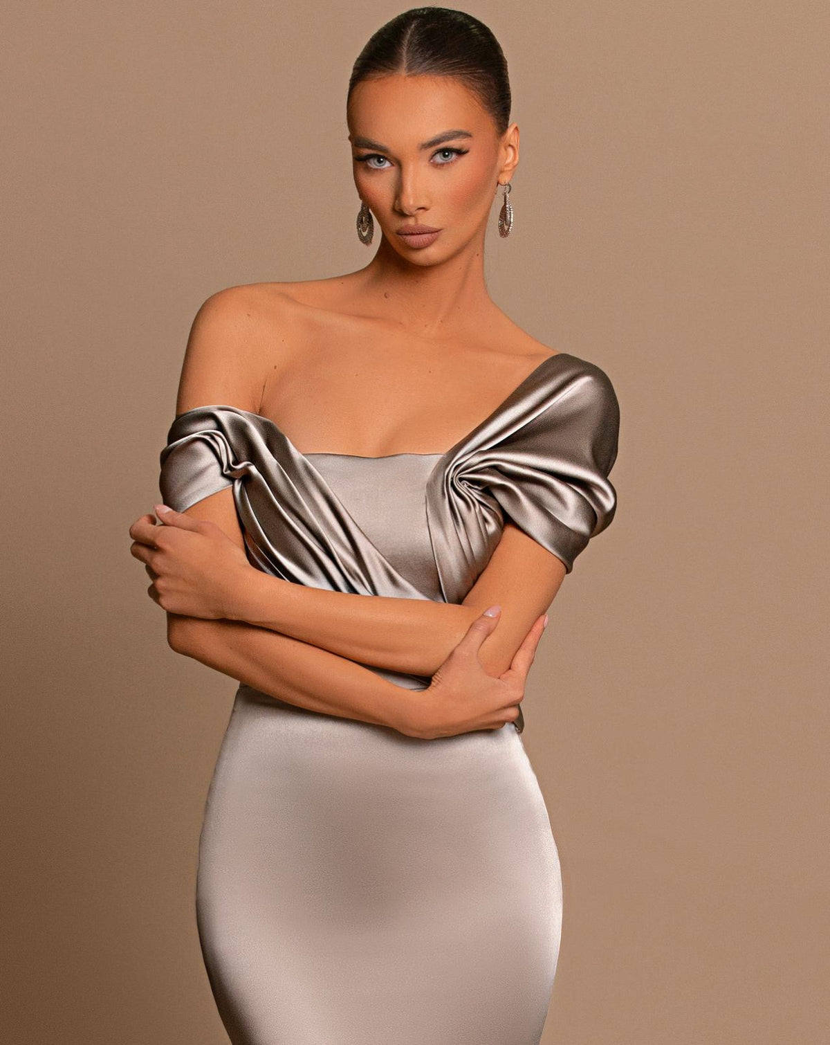 Chrome off-shoulder maxi gown in metallic satin with a structured corset bodice and elegant draped detailing.