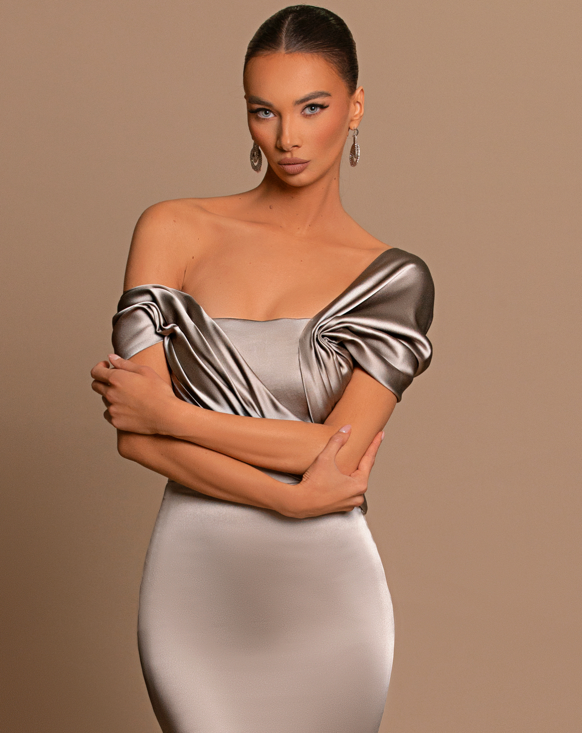 Chrome off-shoulder maxi gown in metallic satin with a structured corset bodice and elegant draped detailing.