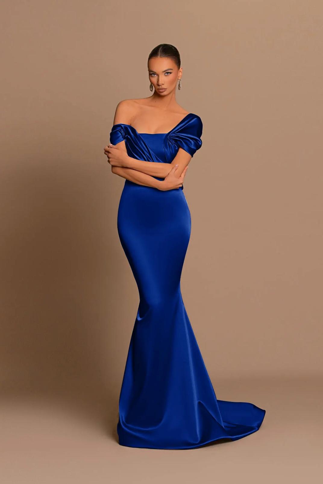 Royal blue off-shoulder satin maxi gown with a structured corset bodice and cascading draped detailing.
