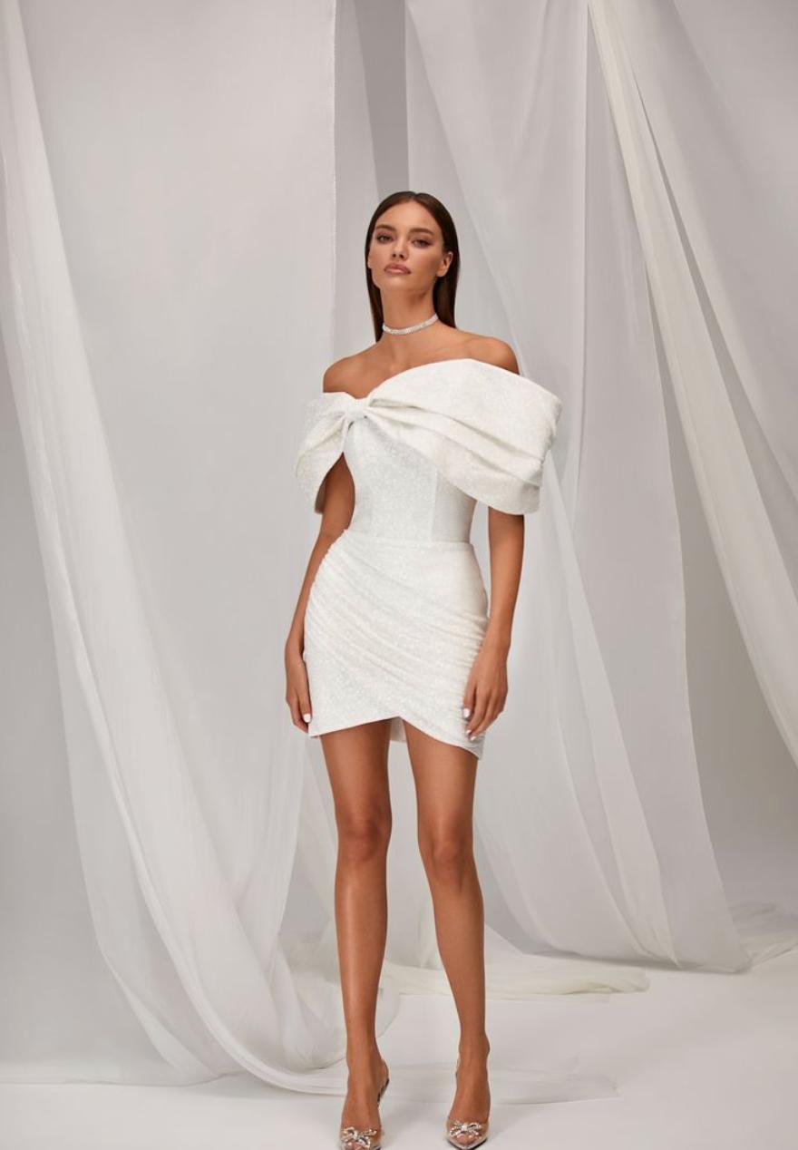 White off-the-shoulder mini dress with a ruched bodice and draped skirt in shimmering satin fabric.