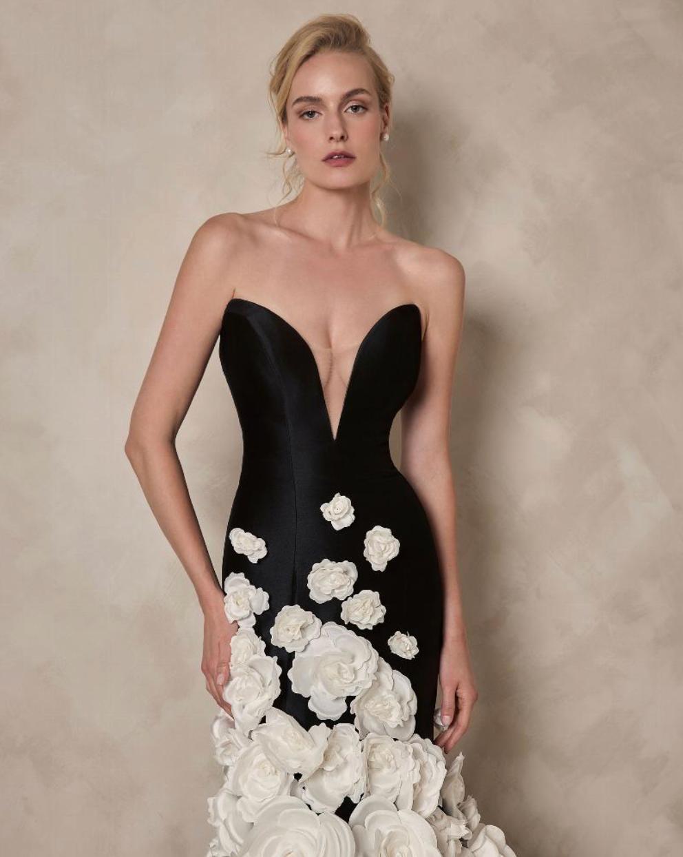 Black strapless satin mermaid gown with a deep V-neck and white floral appliqués.